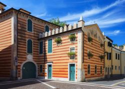 La facciata a righe gialle e rosse di un palazzo a Bardolino, provincia di Verona, Veneto. Si tratta di un tipico esempio di architettura veneta.

