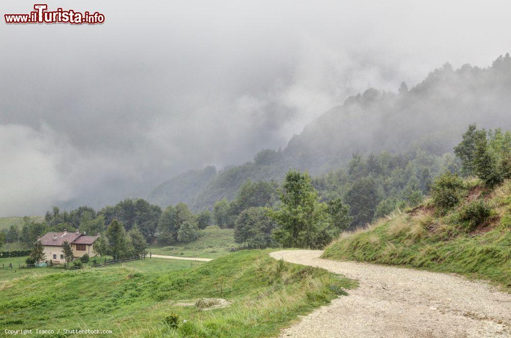Immagine Panorama di un sentiero con una casa sui monti di Montagnole Basse, Alpi italiane, Recoaro Terme, Veneto, in una giornata di foschia - © Isacco / Shutterstock.com