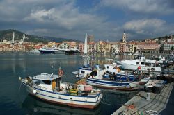 Barche e yachts ormeggiati al porto di Oneglia, Imperia. Sullo sfondo, le pittoresche case di questo borgo marinaro.


