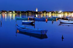 Barche ormeggiate di notte nella laguna di Nin, Croazia. Sullo sfondo, le luci della città antica.
