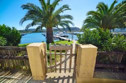 Cancello in legno al porto di Cannigione, Sardegna. Un grazioso ingresso realizzato in legno è l'accesso alla marina di questo centro di villeggiatura del golfo di Arzachena - © ...