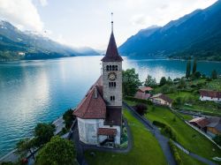 La chiesa di Brienz vista tramite un drone a Interlaken, Svizzera. Sullo sfondo l'omonimo lago alpino formato dal corso del fiume Aar appena prima che il fiume dia vita al lago di Thun.
 ...