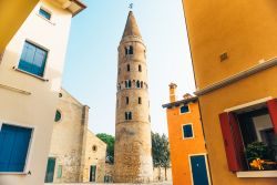 La torre del Duomo di Santo Stefano sul lungomare di Caorle, Veneto. A forma cilindrica, è sormontato da una cuspide conica in stile romanico.

