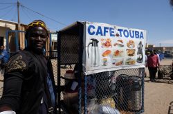 Un uomo musulmano vende il tipico caffè con spezie in una bancarella lungo la strada a Nouakchott, Mauritania - © Lena Ha / Shutterstock.com