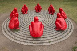 Opera scultorea nota come Meeting in una piazza di Bamberga, Germania. Si tratta di 8 uomini dipinti di rosso, rannicchiati e disposti a cerchio, realizzati da Wang Shugang - © MirasWonderland ...