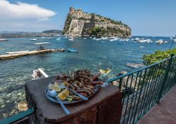 Pesce fritto da gustare con il panorama del Castello Aragonese di Ischia - © esherez / Shutterstock.com