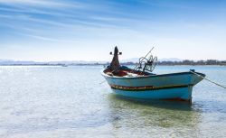 Una tradizionale barca da pesca colorata nel Mar Mediterraneo, Nabeul, Tunisia. La capitale tunisina della ceramica, così viene definita Nabeul, lega il proprio nome anche al turismo ...