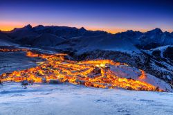 Un pittoresco panorama invernale by nigth dello ski resort dell'Alpe d'Huez, Francia. Questa stazione sciistica è nata nel 1936 ed è una delle più grandi di tutta ...