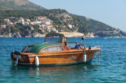 Una barca in legno ormeggiata davanti alle coste di Zaton, Croazia. Questa cittadina è una delle mete preferite dagli abitanti di Dubrovnik per trascorrere il fine settimana in relax ...