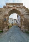 Un'antica porta d'ingresso alla città di Asciano, Toscana. A delimitare il centro storico cittadino sono le mura che un tempo costituivano il sistema difensivo  - © ...