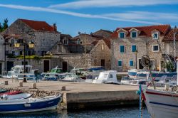 Uno scorcio della cittadina di Prvic Sepurine a Prvic, Croazia: il molo con le barche attraccate e le case in pietra sullo sfondo.
