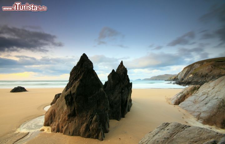 Immagine Spiaggia di Coumeenole nella penisola di Dingle, Irlanda. La sabbia dorata di questo angolo di costa irlandese è impreziosita da bizzarre formazioni rocciose che si innalzano creando un suggestivo paesaggio naturale - © Eric70 / Shutterstock.com