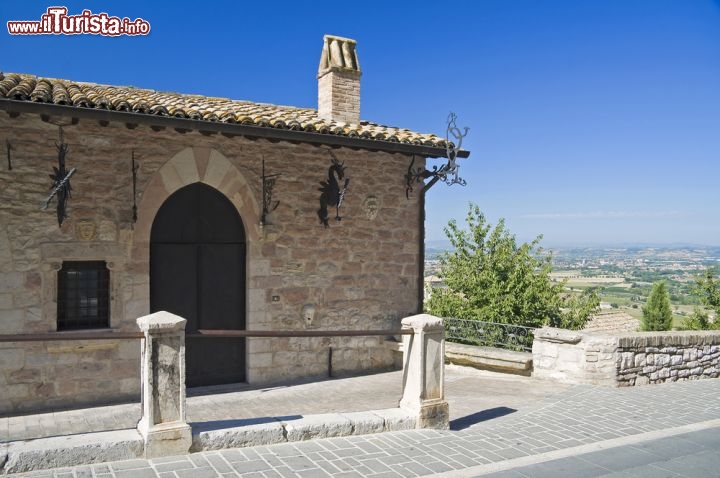 Immagine Un'antica casa nel borgo umbro di Assisi. Benchè vanti un'origine di epoca romana, l'attuale aspetto urbanistico della città così come quello degli edifici e del tessuto urbano derivano dallo sviluppo medievale. Arroccato su una collina, questo borgo di 25 mila abitanti ha un'apparato difensivo costituito da otto porte di accesso fortificate e da una lunga cinta muraria ancora in perfetto stato di conservazione - © Mi.Ti. / Shutterstock.com