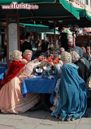 Immagine Carnevale di Venezia: alcune maschere si ritorano in un un ristorante del Sestiere Castello - © Radu Razvan / Shutterstock.com