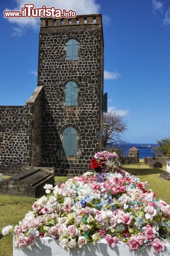 Immagine Il Cimitero dell'Isola di Sint Eustatius (Caraibi Olandesi) - A differenza della cultura occidentale che con la parola "cimitero" non solo identifica un luogo sacro dove riposano i morti ma anche una dimensione piuttosto intima e severa, nei Caraibi Olandesi la concezione cambia completamente. Come si evince dall'immagine, infatti, il cimitero qui sorge all'aperto, dove narcisi e altri fiori dai colori sgargianti non sembrano contornare qualcuno che non c'è più ma piuttosto, celebrare chi non è più in vita come se in realtà ancora lo fosse - © R.A.R. de Bruijn Holding BV / Shutterstock.com