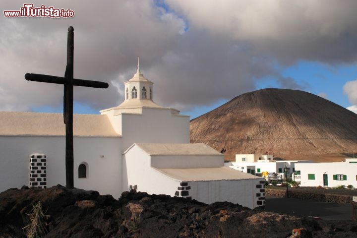 Immagine La chiesa di Mancha Blanca a Lanzarote (Canarie), con il vulcano sullo sfondo  - © John Copland / Shutterstock.com