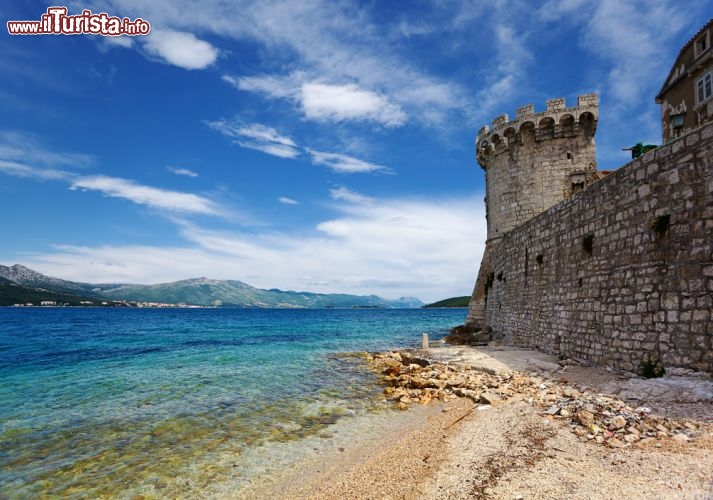 Immagine Forte di Korcula, lungo la cinta muraria del borgo, e il mare limpido di una delle spiagge più spettacolari della Croazia e delle isole della Dalmazia - © OPIS Zagreb / Shutterstock.com