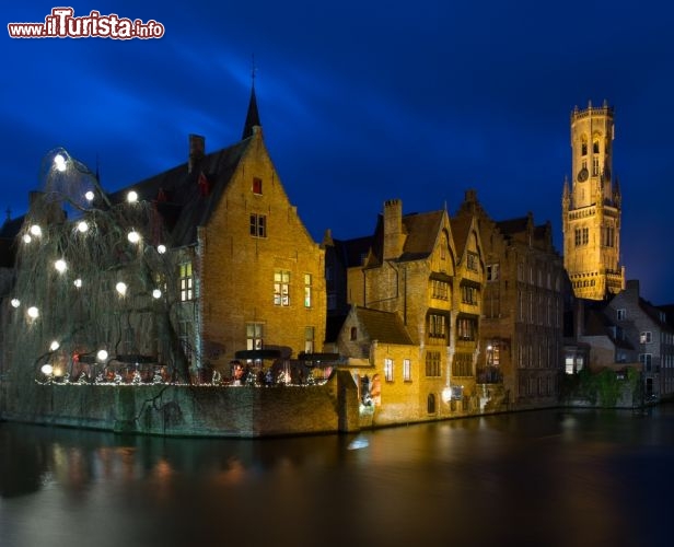 Immagine Fotografia notturna di Bruges, Belgio - Atmosfera magica per le festività natalizie di Bruges quando i canti di Natale si diffondono nell'aria e le illuminazioni con cui la città è addobbata a festa si rispecchiano nelle acque dei canali. La Venezia del Nord, che nel periodo dell'Avvento si presenta con decorazioni natalizie e un grande presepe allestito vicino alla pista da ghiaccio, accoglie migliaia di turisti che scelgono questo periodo dell'anno per visitarla © Nejron Photo / Shutterstock.com
