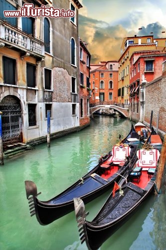 Immagine Gondole in un canale di Venezia. Le godole sono le imbarcazioni tipiche di venezia, e prima dell'avvento dei motori fuoribordo, il mezzo migliore per muoversi dentro Venezia. Le barche sono oggi utilizzate soprattutto dai turisti, che possono così sperimentare il modo più romantico per visitare la città lagunare - © leoks / Shutterstock.com