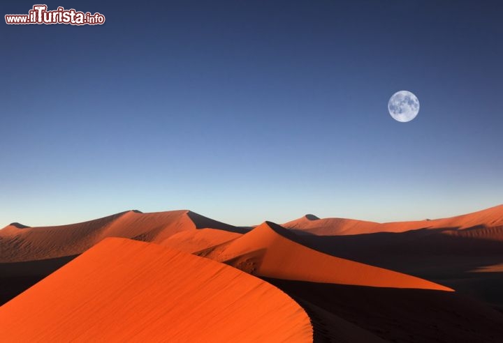 Immagine La Luna piena sorge al tramonto del sole sulle coloratissime dune di sabbia di Sossusvlei in Namibia - © Dietmar Temps / Shutterstock.com