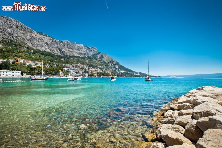 Immagine Il mare cristallino di Omis in Dalmazia, a sud di Spalato in Croazia. La zona di Omis vanta numerose spiagge, spesso di ciottoli ma in alcuni casi anche sabbiose. Il mare qui è reso calmo dalla presenza nelle vicinanze dell'isola di Brac. Tra le spiagge di Omis segnaliamo quella di Duce, Lokva Rogoznica, Marusici e Medici - © alexdrim / Shutterstock.com