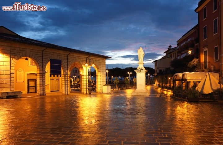 Immagine Panorama notturno su Piazza Malvezzi, Desenzano del Garda - Lo splendido piazzale contornato da portici, opera dell'architetto Giulio Todeschini, rappresenta il cuore di Desenzano del Garda dove Piazza Malvezzi raccoglie palazzi di grande prestigio artistico oltre a ristoranti e raffinati negozi. L'origine del centro storico di questa città moderna, che affonda le sue radici nel passato, risalirebbe al Cinquecento © Kiril Stanchev / Shutterstock.com