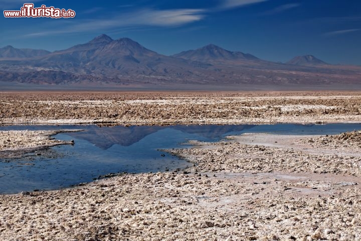 Immagine Il Salar de Atacama in Cile è una vasta pianura arida, dove si trova una elevata concentrazioni di sali. Qui non piove praticvamente mai, però il deserto riceve le acque dalle vicine cime sulle delle Ande.Le acque si fermano in questa depressione ed evaporando lasciano le croste di sali - © Nataliya Hora / Shutterstock.com