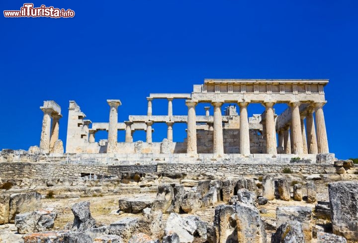 Immagine Il più importante sito archeologico di Egina si trva a poca distanza da Agia Marina: su di una altura si trovano le rovine elleniche del Tempio di Atena Aphaia, in classico stile dorico e dedicato alla divinità Afea che poi venne sostituita da Atena, da cui il nome. Siamo nel Golfo Saronico, vicino al Peloponneso, in Grecia - © Tatiana Popova / Shutterstock.com