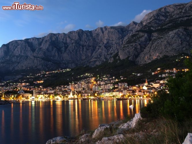 Immagine La costa di Makarska, in Croazia: vista notturna della città e dei monti del massiccio del Biokovo alle spalle della riviera - © emberiza / Shutterstock.com