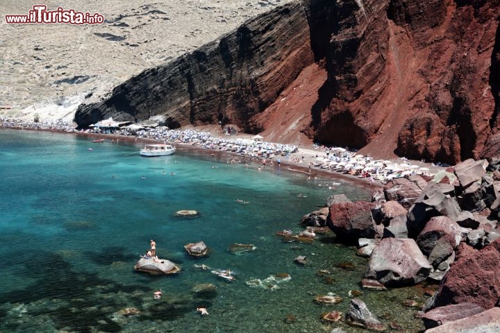 Immagine La celebra spiaggia rossa di Thira, sulla costa sud dell'isola di Santorini nell'arcipelago delle Cicladi in Grecia. Il colore particolare è dovuto alle rocce vulcaniche: l'isola di Santorini è in realtà l'anello di una grande caldera vulcanica che esplose circa 3.600 anni fa, ponendo fine alla civiltà minoica, apportando gravi danni anche alla vicina isola di Creta. Santorini è tuttora un vulcano considerato attivo e ci sono timori per un possibile ripresa della sua attività, nei prossimi decenni - © Paul Cowan / Shutterstock.com