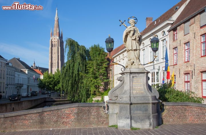 Immagine Statua di Giovanni Nepomuceno, Bruges - Considerato il protettore delle persone in pericolo di annegamento, questo religioso boemo - proclamato santo da papa Benedetto XIII nel 1729 - fu fatto uccidere da re Venceslao nel 1393 che ordinò di gettarlo nel fiume Moldava dopo averlo sottoposto a numerose torture. In suo onore anche la città di Bruges ospita un gruppo scultoreo realizzato sul ponte di uno dei tanti canali che attraversano il centro storico e da cui si può ammirare anche il panorama sulla chiesa di Nostra Signora © Renata Sedmakova / Shutterstock.com