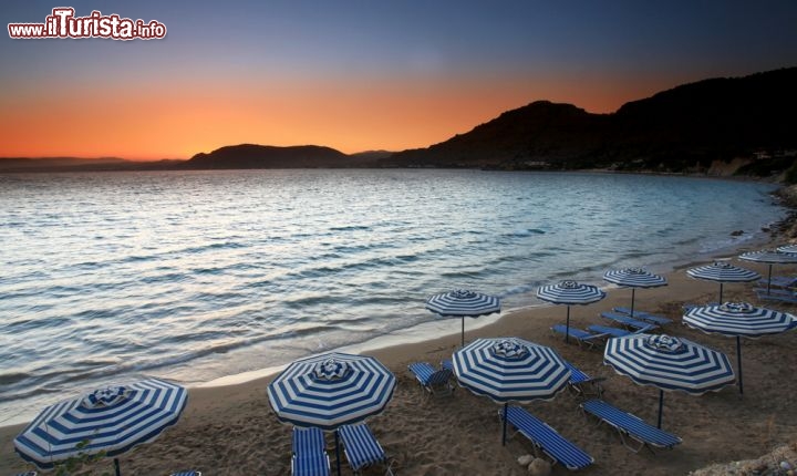 Immagine Tramonto sulla spiaggia di Pefkos a Rodi, Grecia - Riflessi color arancio nel cielo di Rodi al calar del sole. In questa immagine, un bel tramonto sulla spiaggia di Pefkos, 5 chilometri a sud di Lindos. In greco Pefkos significa "albero di pino": proprio questi alberi, numerosi sia in paese che nei dintorni, ne profumano l'aria  © Birute Vijeikien / Shutterstock.com