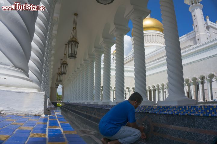 Immagine Abluzioni nella moschea Omar Ali Saifuddien, Brunei - Se all'esterno è circondata da un gran numero di alberi e giardini fioriti, a simboleggiare il paradiso, l'interno della moschea Omar Ali Saifuddien ha pareti rivestite di marmo bianco con tappeti pregiati che arrivano da Iran e Arabia Saudita oltre che splendide vetrate e candelabri di produzione inglese. Non manca neppure il granito di Shanghai. Con la cupola d'oro posta a 52 metri di altezza sullo sfondo, un fedele è intento all'abluzione, il lavaggio rituale a scopo di purificazione spirituale © AHMAD FAIZAL YAHYA / Shutterstock.com