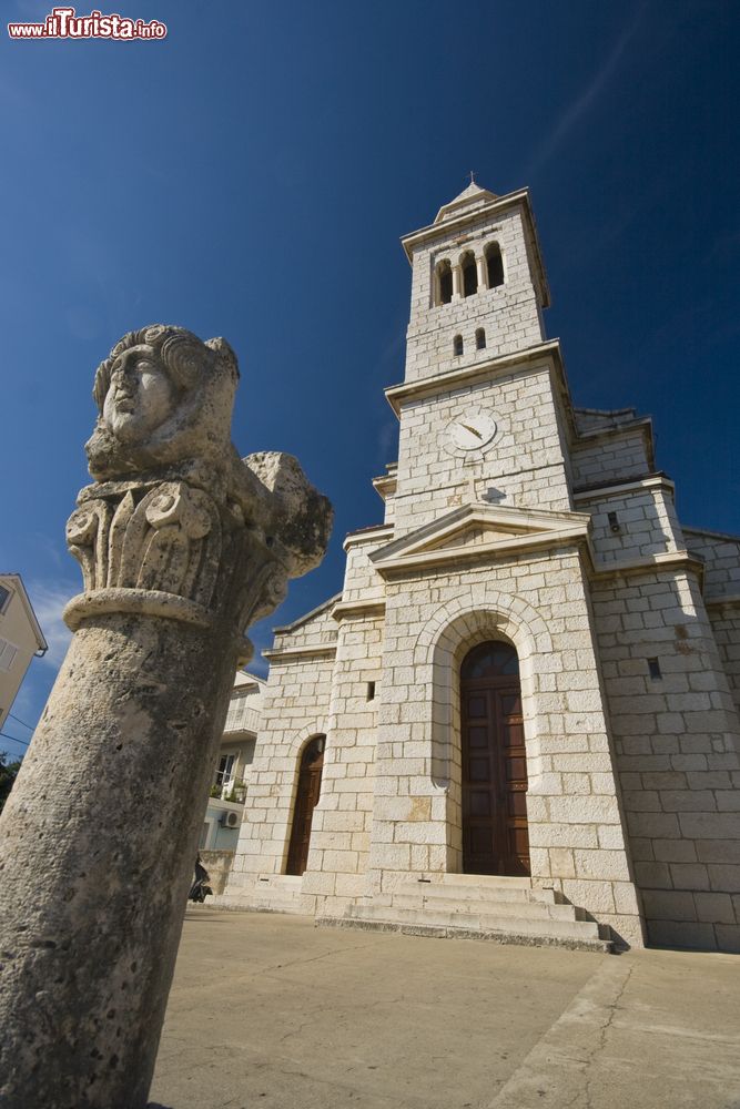 Immagine Antica colonna e chiesa della Santa Trinità nella città di Pakostane, Croazia.