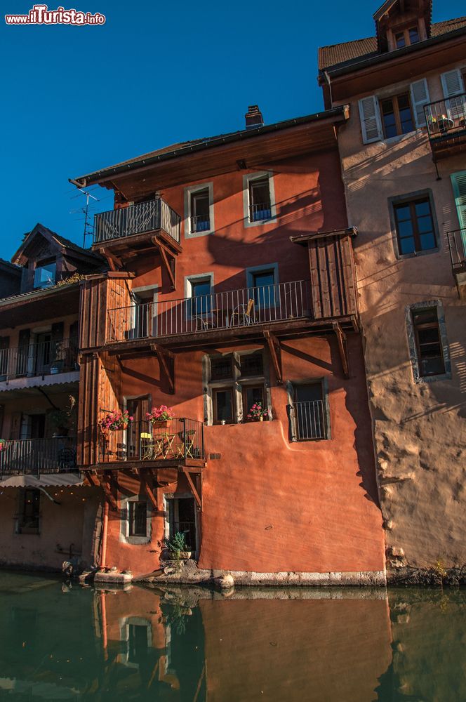 Immagine Antichi palazzi nel centro storico di Annecy, Francia. Fotografati dal lato opposto del canale, sono illuminati dalla luce calda del tramonto.