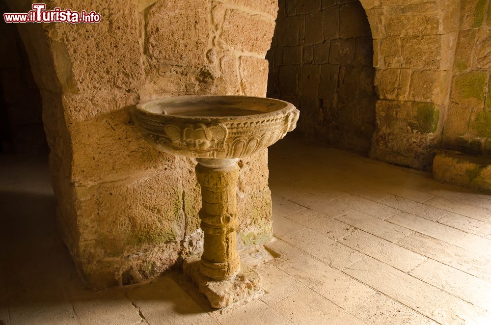 Immagine Un'antica fonte nella chiesa di San Giovanni di Sinis, Sardegna. All'interno di questo edificio religioso dedicato a San Giovanni Battista si può ammirare questo splendido fonte in pietra riccamente decorato.