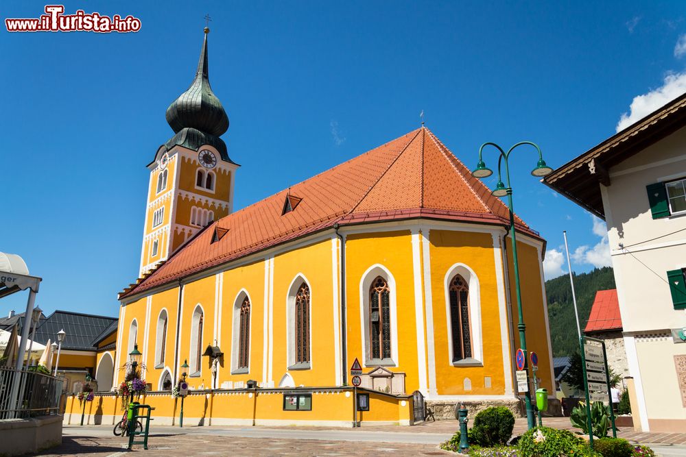 Immagine Architettura religiosa nel centro di Schladming: la chiesa cattolica con la facciata color ocra e il campanile a bulbo.