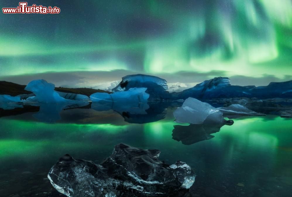 Immagine Aurora boreale al Jokulsarlon Glacier Lagoon, Islanda. Questa laguna di origine glaciale fluisce nell'Oceano Atlantico attraverso un breve canale lasciando blocchi di ghiaccio su una spiaggia di sabbia nera.