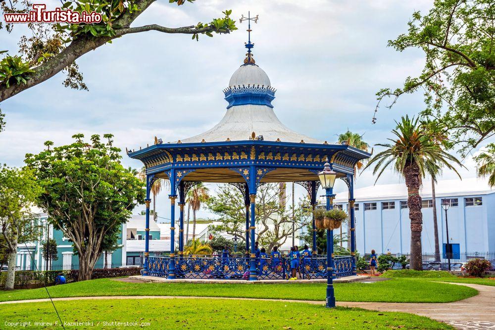 Immagine Bambini con l'uniforme scolastica giocano nel vecchio gazebo di Victoria Park, Hamilton, isola di Bermuda. Questo parco pubblico, aperto tutti i giorni nelle ore diurne, ospita concerti e eventi culturali. Al suo centro si trova un bel chiosco per la musica installato nel 1889 per commemorare il Giubileo d'Oro della regina Vittoria. E' stato rinnovato nel 2008 - © Andrew F. Kazmierski / Shutterstock.com