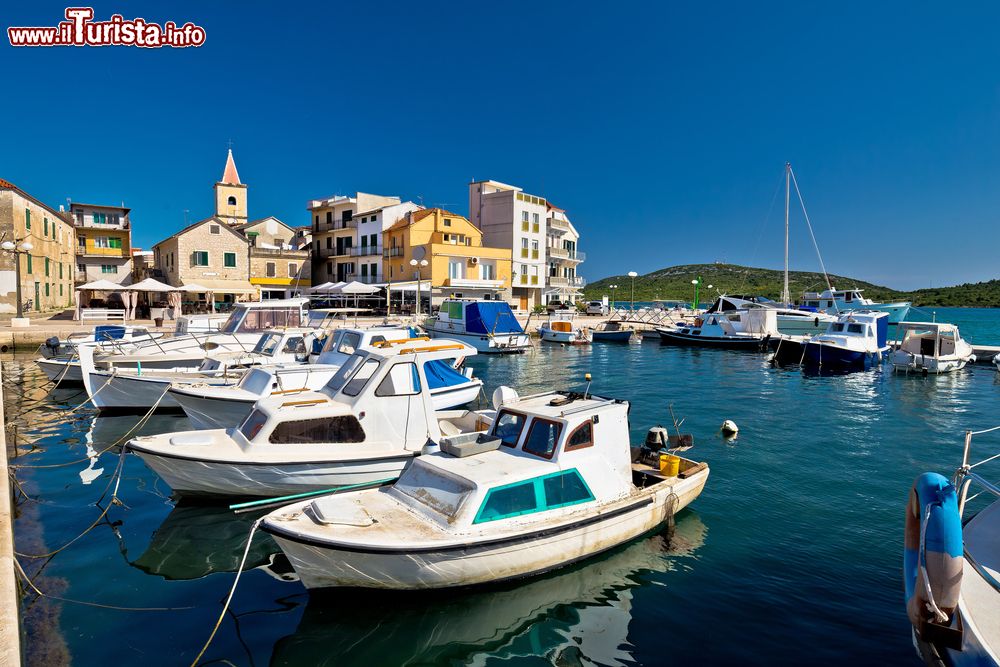 Immagine Barche al porto di Pirovac, Croazia. Sullo sfondo, le tradizionali case di questo villaggio costiero.