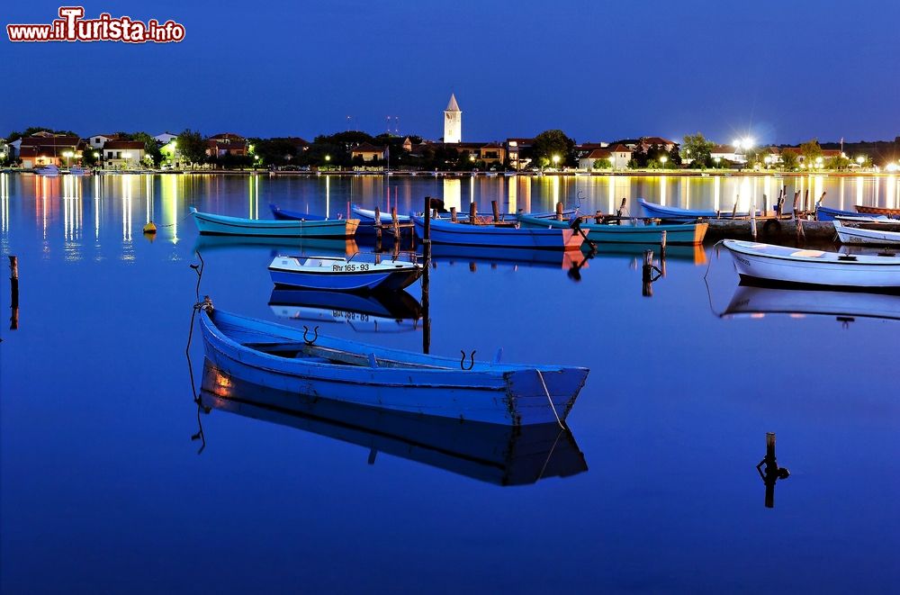 Immagine Barche ormeggiate di notte nella laguna di Nin, Croazia. Sullo sfondo, le luci della città antica.