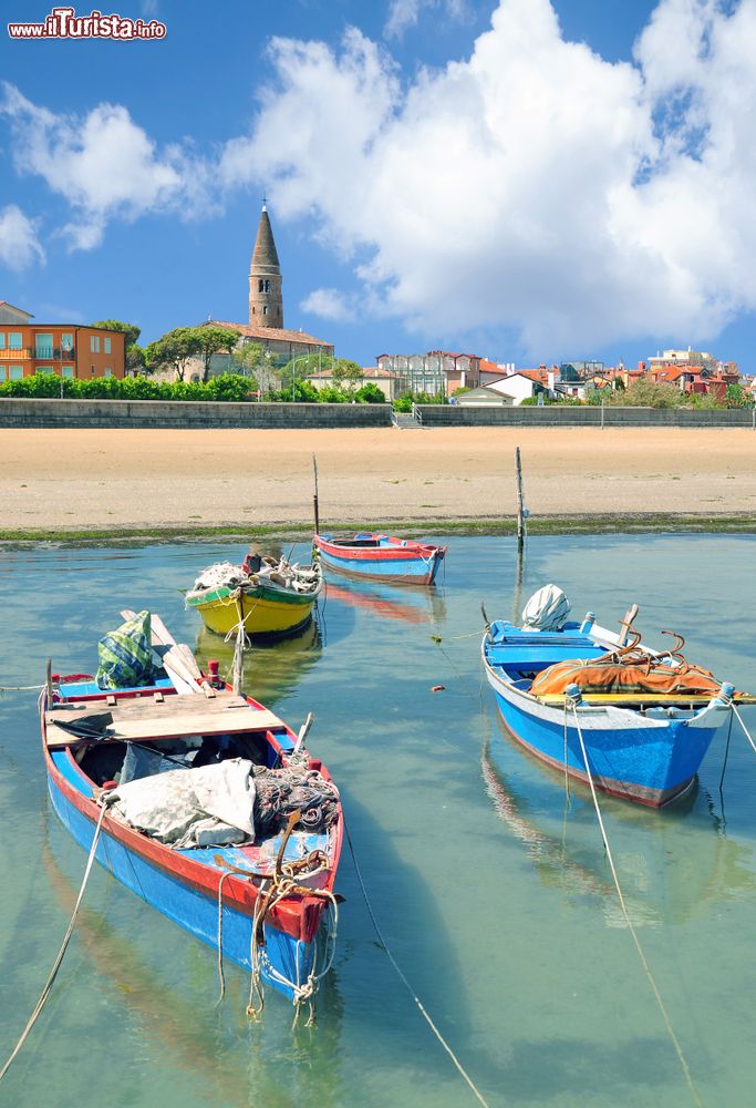 Immagine Barche ormeggiate vicino alla spiaggia di Caorle, Veneto. Sullo sfondo, il bel borgo alle porte di Venezia situato alla foce dei fiumi Livenza e Lemene.