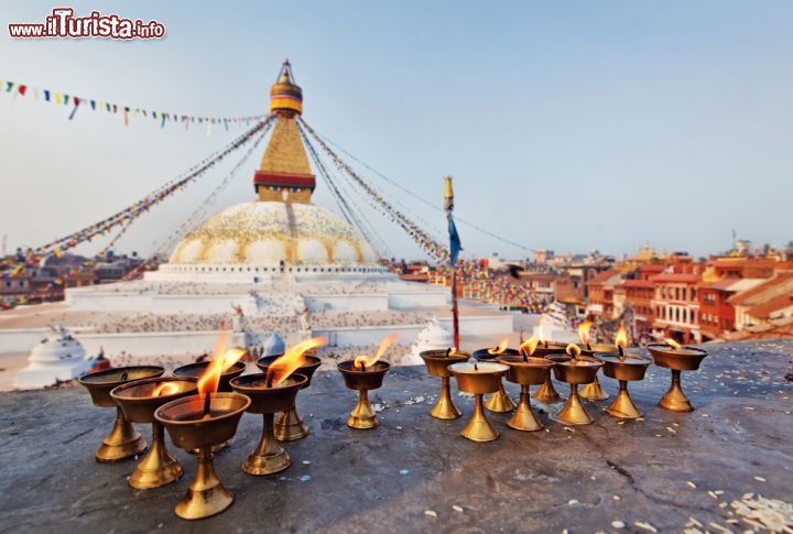 Immagine Candele sacre al Boudhanath di Kathmandu, Nepal. Questo stupa, uno dei più grandi del Nepal, domina lo skyline della città con la sua altezza di 36 metri. Dal 1979 è patrimonio Unesco. Il terremoto del 2015 ha causato lievi danni a questo edificio - © HamsterMan / Shutterstock.com