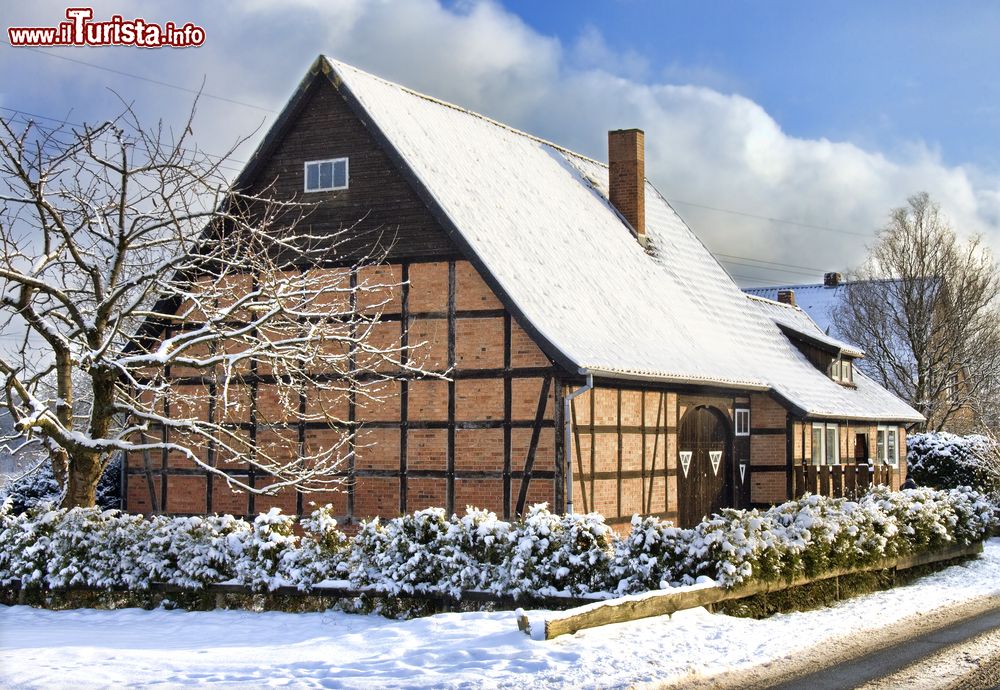 Immagine Edificio in mattoni dal tetto spiovente coperto di neve nelle campagne di Luneburg