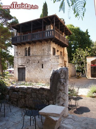 Immagine Casa romanica nel villaggio di Porec, Croazia. Questo edificio, risalente al XIII° secolo, si trova nel punto d'incontro della via Decumanus e di piazza Marafor. Di grande interesse sono il balcone in legno, la bifora romanica e l'archivolto monolitico - © Jarno Gonzalez Zarraonandia / Shutterstock.com