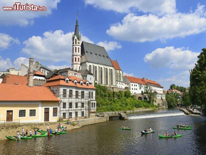 Immagine Scorcio del centro storico di Cesky Krumlov, Repubblica Ceca: la Moldava incontra la Chiesa di San Vito - La splendida chiesa gotica dedicata a San Vito svetta su tutta la città grazie alla sua torre, insieme al castello naturalmente, e qui in questo scorcio, si nota come essa sia situata proprio su una sponda dell'imponente Moldava, uno dei più grandi fiumi dell'Europa centrale nonché grande punto di attrazione turistica di Cesky Krumlov. Una gita in barca sul fiume offre infatti panorami a dir poco mozzafiato su questa splendida città e sulle colline che la circondano. - © Pecold / Shutterstock.com