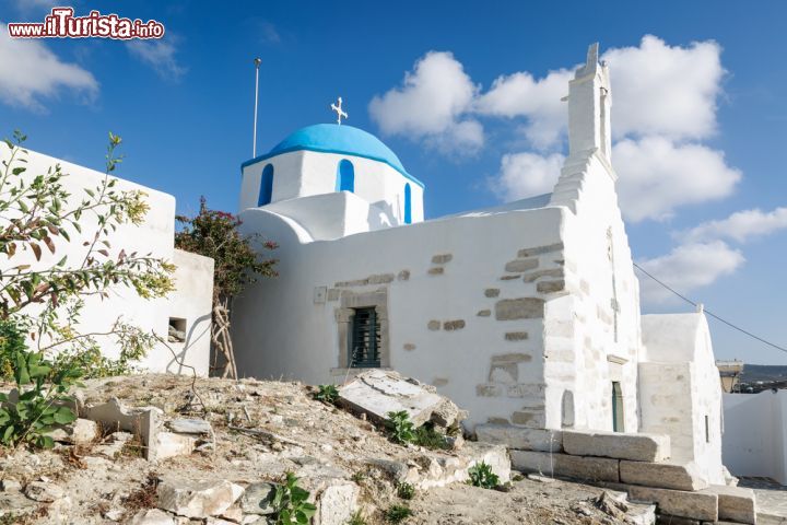 Immagine Chiesa di Parikia, isola di Paros, Grecia. La cupola color azzurro cielo sovrastata da una croce contrasta con il bianco della calce che riveste i muri esterni, costruiti in sasso, di questo suggestivo edificio religioso delle Cicladi - © Sabino Parente / Shutterstock.com