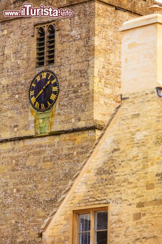 Immagine Chiesa in pietra di St Mary e orologio a Bibury, Inghilterra - Particolare della facciata in pietra color miele e dell'orologio che impreziosisce la chiesa di Santa Maria nel borgo di Bibury © Voyagerix / Shutterstock.com