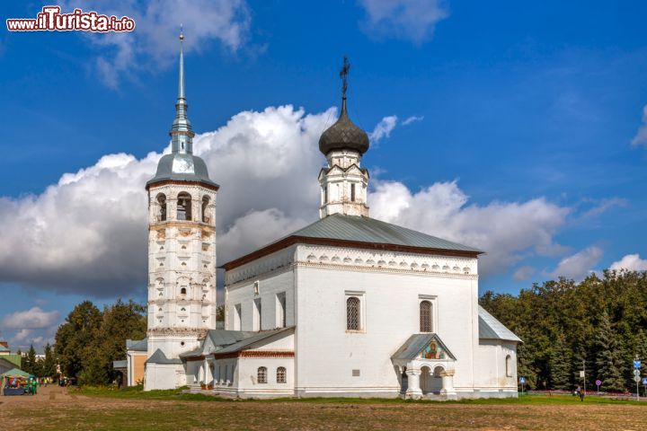 Immagine Chiesa della Resurrezione a Suzdal, Russia  - Il punto migliore per cominciare la visita di Suzdal è la piazza del mercato:il suo lungo porticato, costeggiato da colonne, termina in una guglia con una banderuola a forma di falco, antico simbolo della città. A completare questo quadro d'insieme è la bella chiesa della Resurrezione con la facciata bianca impreziosita da coperture color grigio © Sergey Lavrentev / Shutterstock.com