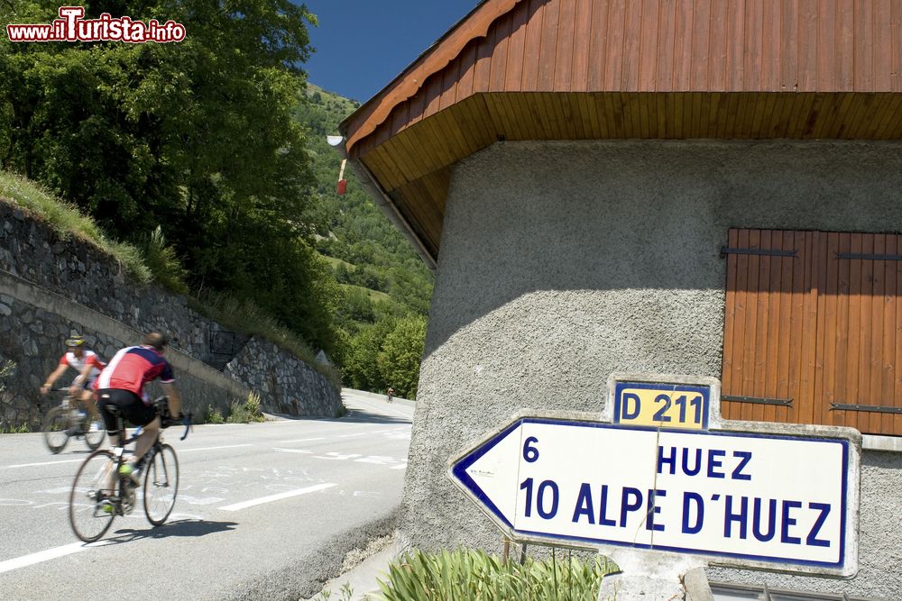 Immagine Ciclisti pedalano all'Alpe d'Huez, Francia: la strada che sale qui ha 21 tornanti, ognuno dei quali è caratterizzato da una targa a ricordo di uno dei vincitori della tappa del Tour de France.